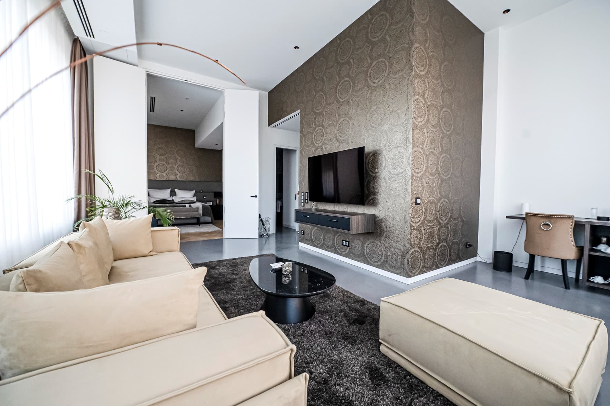 Luxurious suite bedroom with floor-to-ceiling windows and elegant furnishings